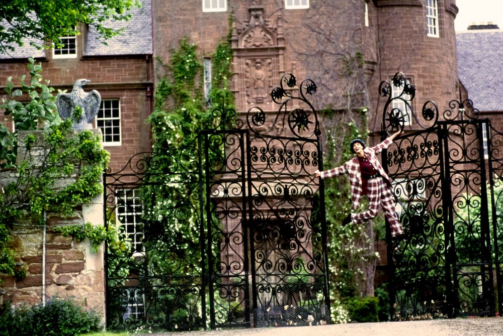 Model Linda Evangelista swinging on the tall gates of Beaufort Castle. Photographed on the private Victorian estate of...