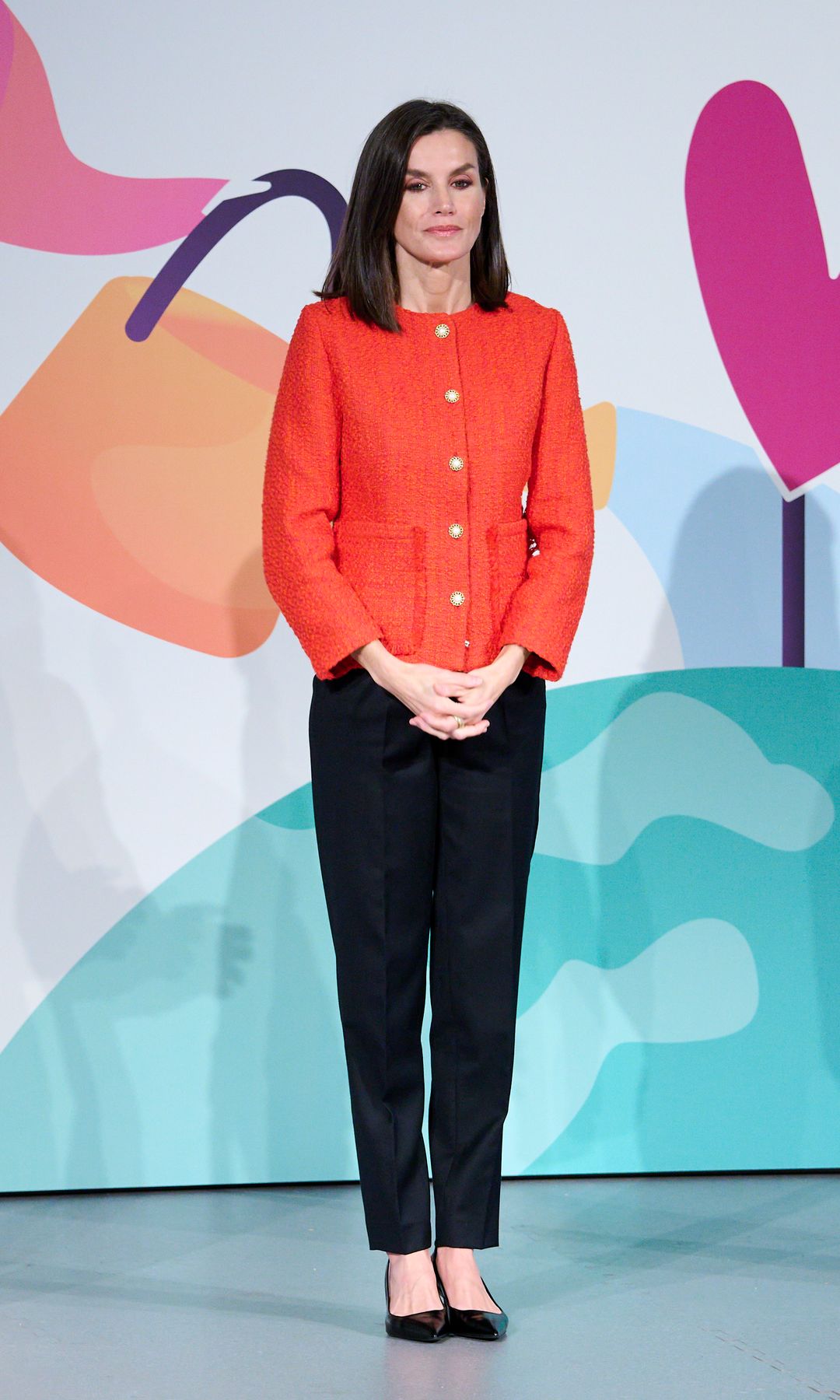 La reina Letizia con pantalón de traje negro y chaqueta roja